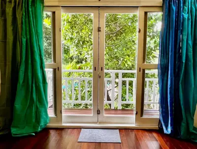 a room with a large window with blue curtains at The Backyard 28 in Khlong Toei