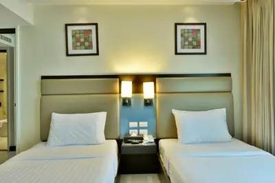two beds sitting next to each other in a room at The Prestige Nana in Bangkok