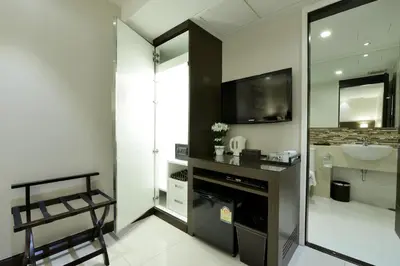 a bathroom with a sink and a television in a room at The Prestige Nana in Bangkok