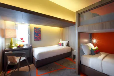 a hotel room with two beds and a desk and a bed at Tinidee Trendy Bangkok Khaosan in Bangkok