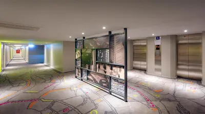 a hallway with colorful drawings on the floor of a building at Tinidee Trendy Bangkok Khaosan in Bangkok