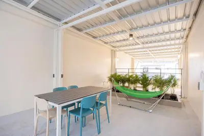 a dining room with a table and chairs and a hammock at Theme Stories - Boutique Guesthouse in Bangkok