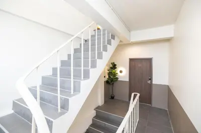 a staircase in a house with white walls and gray stairs at Theme Stories - Boutique Guesthouse in Bangkok