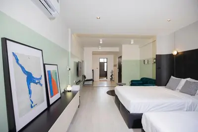 a hotel room with two beds and a couch at Theme Stories - Boutique Guesthouse in Bangkok