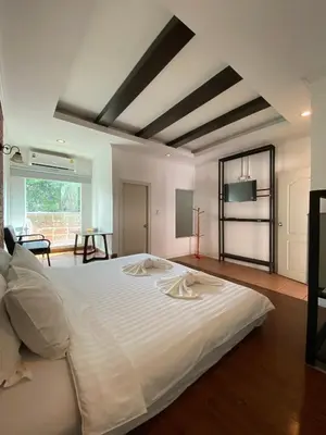 a large white bed in a room with a table at เดอะวิลล่า71 รีสอร์ท in Ban Zong Katiam
