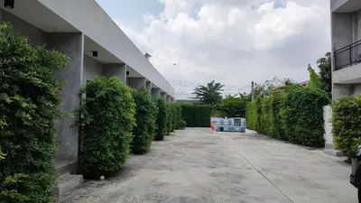 a courtyard with a row of bushes next to a building at The Loftel Resort in Bangkok