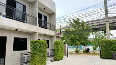 a building with green bushes in front of it at The Loftel Resort in Bangkok