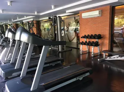 a gym with several treadmills and a brick wall at Marigold Ramkhamhaeng in Bangkok