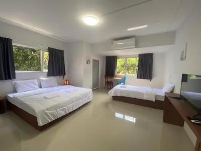 a bedroom with two beds and a television in it at ศิวพฤกษ์ เพลส in Nonthaburi