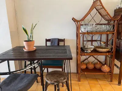 a dining room table with a plant and a chair at Baan KhaoSoi - Private room in a rooftop hostel 3rd floor in Khlong San