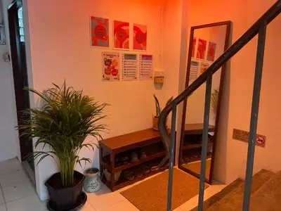 a hallway with a staircase with a potted plant at Baan KhaoSoi - Private room in a rooftop hostel 4th floor in Khlong San