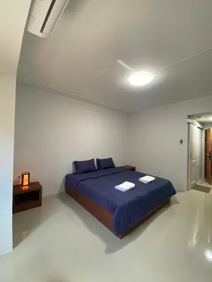 a bedroom with a blue bed in a white room at ศิวพฤกษ์ เพลส in Nonthaburi