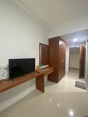 a living room with a television on a wooden desk at ศิวพฤกษ์ เพลส in Nonthaburi