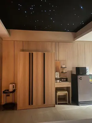 a kitchen with a refrigerator and a table with a microwave at Rema residence China town Main Road in Bangkok