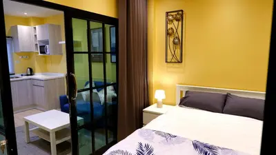 a small bedroom with a bed and a kitchen at BEB Silom Condolette in Bangkok