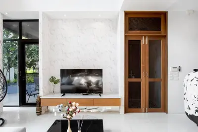 a living room with a tv on a wall at Bangkok Luxury Pool Villa Thonglor in Bangkok