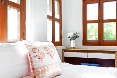 a bedroom with a bed and a vase of flowers at Sathorn Private Pool Villa in Bangkok