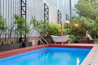 a bath tub sitting next to a swimming pool at Sathorn Private Pool Villa in Bangkok