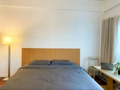 a bedroom with a bed and a desk with a laptop at Huge Living Room + 5 bedrooms with Private baths in Bangkok
