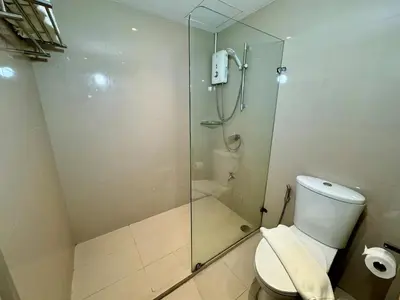 a bathroom with a glass shower with a toilet at Thomson Hotel Huamark in Bangkok