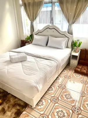 a bedroom with a large white bed with a window at Guesthouse Station in Bangkok