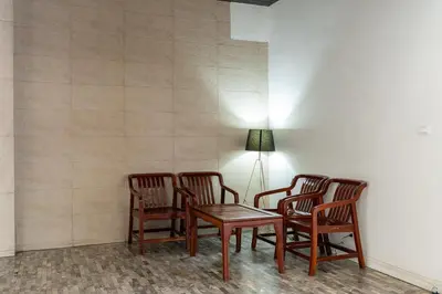 a room with four chairs and a table and a lamp at 23 AVA at Saladaeng in Bangkok
