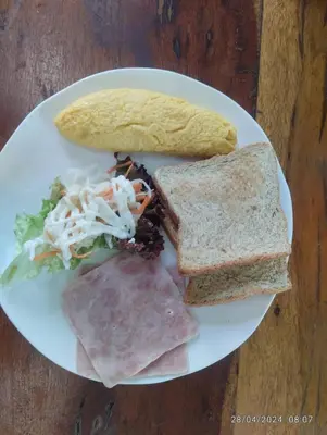 a plate of food with a sandwich and bread at Cacha Hotel in Bangkok