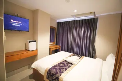 a hotel room with a bed and a tv at L'Hotel Bangkok in Bangkok