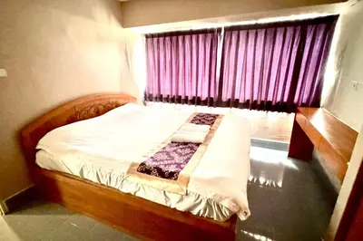 a small bed in a room with a window at L'Hotel Bangkok in Bangkok