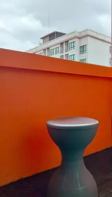 a green toilet sitting next to an orange fence at Guesthouse Bangkok BM B&B in Bangkok