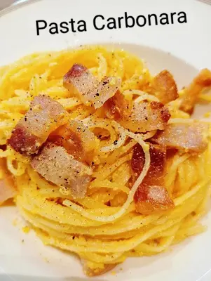 a plate of pasta carbonara on a white plate at Guesthouse Bangkok BM B&B in Bangkok