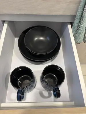 two bowls and a plate on a shelf in a drawer at Sukhumvit​ 101 in Phra Khanong