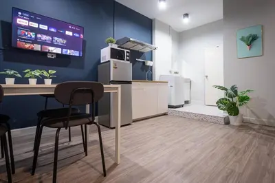 a kitchen with a table and two chairs and a tv at A2 Comfortable space wt Kitchen in Bangkok
