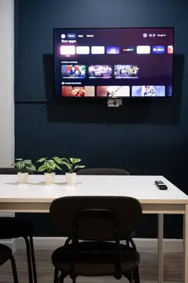 a table with chairs and a tv on a wall at A2 Comfortable space wt Kitchen in Bangkok