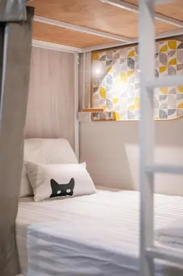 a bed with a black cat head on a pillow at Unplugged at Bangrak Design Hostel in Bangkok