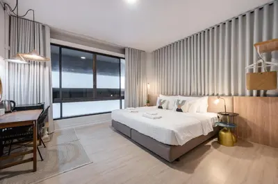 a bedroom with a large bed and a desk and a desk at Unplugged at Bangrak Design Hostel in Bangkok