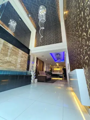 a lobby of a hotel with a chandelier at Masters Suites Hotel in Makkasan