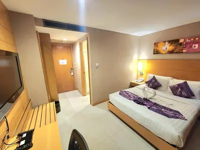 a hotel room with a bed and a flat screen tv at Masters Suites Hotel in Makkasan