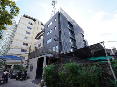 a tall building with a clock on the side of it at Dancenter Rq Bangkok Huai Khwang in Bangkok