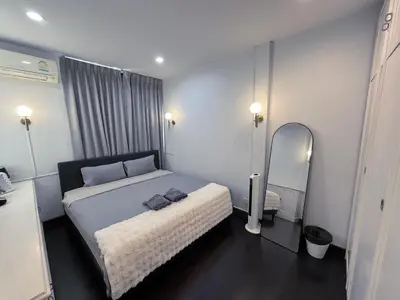 a bedroom with a bed and a mirror in it at Single house 4BR parking and kitchen in Sukhumvit49-1 in Bangkok