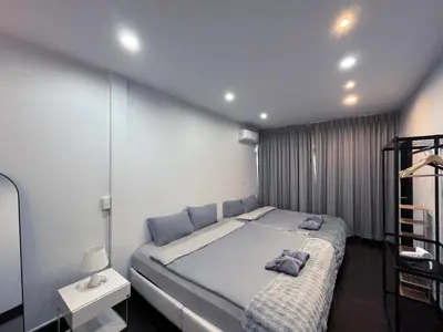 a bedroom with a large bed with two pillows on it at Single house 4BR parking and kitchen in Sukhumvit49-1 in Bangkok