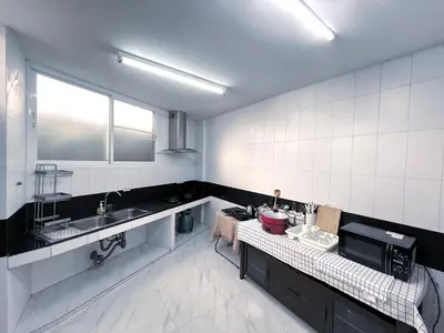 a white tiled kitchen with a sink and a microwave at Single house 4BR parking and kitchen in Sukhumvit49-1 in Bangkok