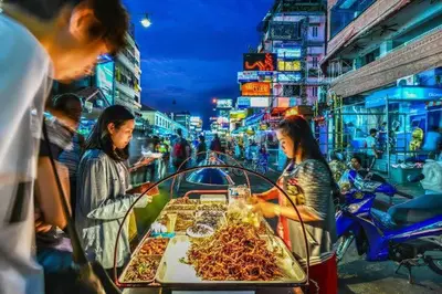 a group of people buying food in a market at wonderful hostel khaosan in Bangkok