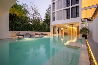 a swimming pool in front of a building at Saan Hotel Sathorn in Bangkok