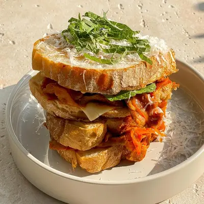 a sandwich on a plate on a table at Saan Hotel Sathorn in Bangkok