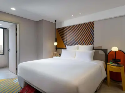 a large white bed in a hotel room at TRIBE Living Bangkok Sukhumvit 39 by AccorHotels in Bangkok