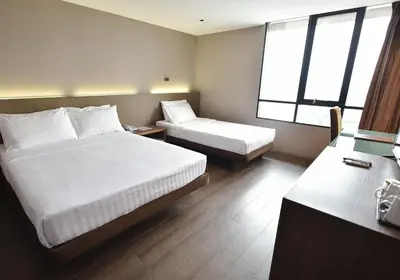 a hotel room with two beds and two windows at Bangkok City Hotel in Bangkok