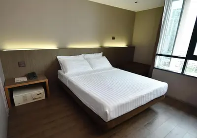 a bedroom with a bed with white sheets and pillows at Bangkok City Hotel in Bangkok