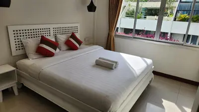 a bedroom with a large white bed with red pillows at Narastay @ Phrom Phong in Bangkok