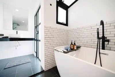 a white bathroom with a tub and a sink at Mitt Haus (Lat Phrao Soi 5) in Bang Su